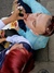 An overhead view of a young couple sitting on a curb, sharing a tray of fries. The woman with red hair is feeding fries to the man, who is leaning back with his eyes closed in enjoyment.